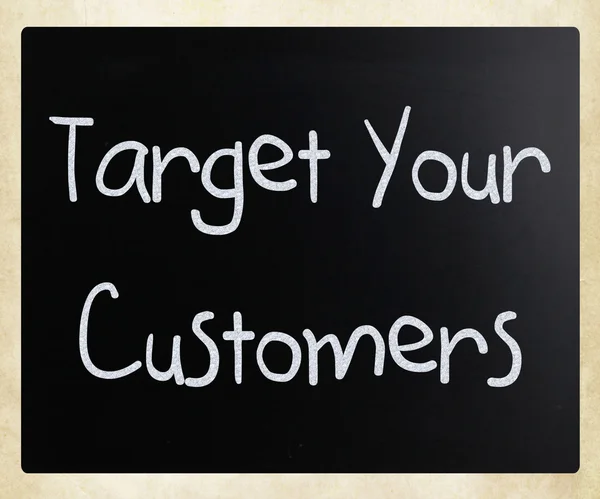 "Target your customers" handwritten with white chalk on a blackb — Stockfoto