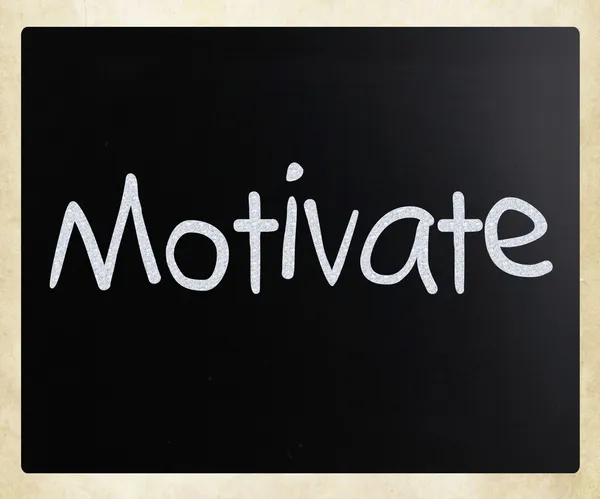 "Motivate "handwritten with white chalk on a blackboard — стоковое фото