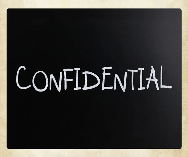 The word "Confidential" handwritten with white chalk on a blackb — Stock Photo, Image