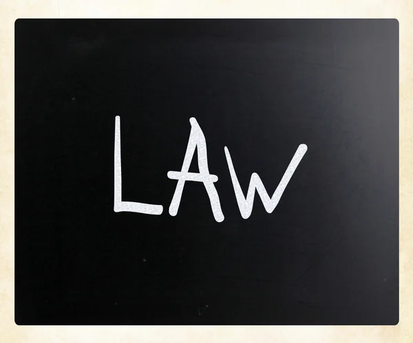 Слово "закон" написано от руки белым мелом на доске — стоковое фото
