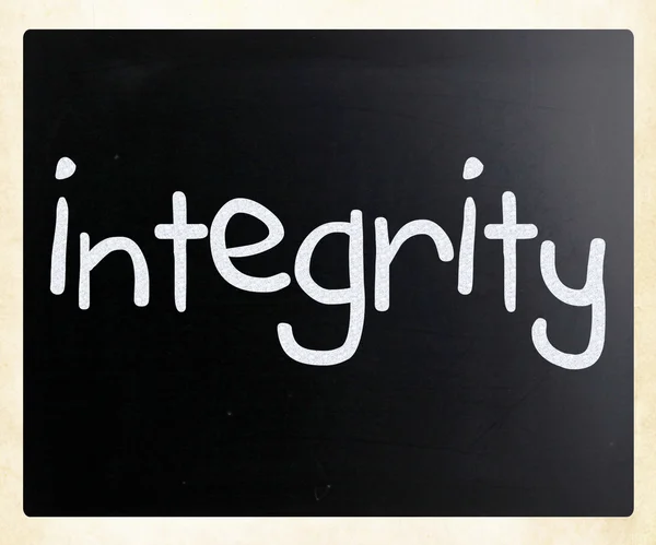 "Integrita"rukou s bílou křídou na tabuli — Stock fotografie