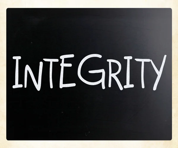 "Integrita"rukou s bílou křídou na tabuli — Stock fotografie