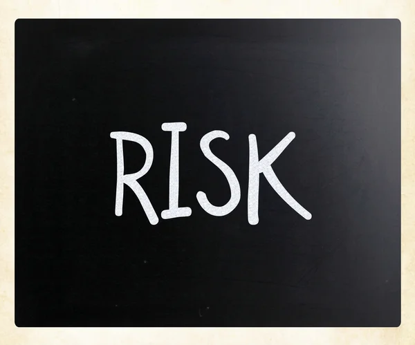 Le mot "risque" écrit à la main avec de la craie blanche sur un tableau noir — Photo