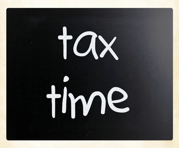 "Tax time" handwritten with white chalk on a blackboard — Stockfoto