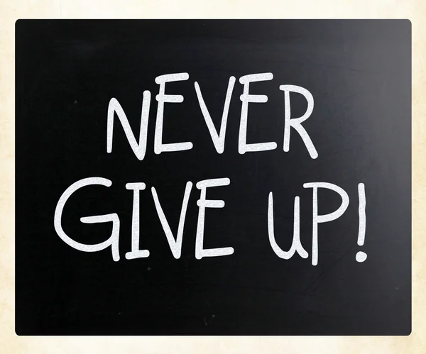 "永不放弃"手写用白色粉笔在黑板上 — 图库照片