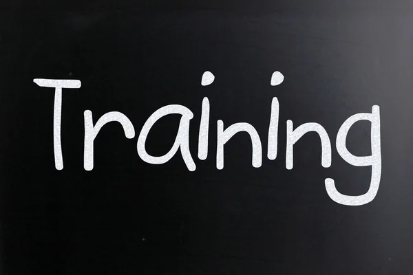 Слово "тренировка" написано от руки с белым мелом на доске — стоковое фото