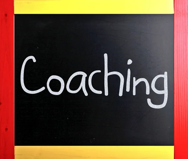"Coaching" handwritten with white chalk on a blackboard — Stock Photo, Image
