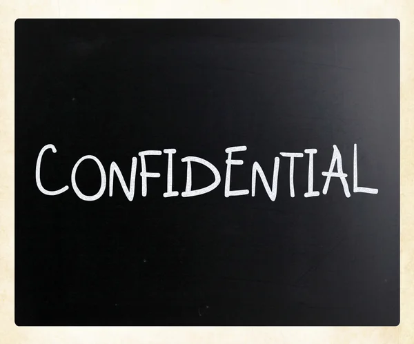 Ordet "konfidentiell" handskrivna med vit krita på en blackb — Stockfoto