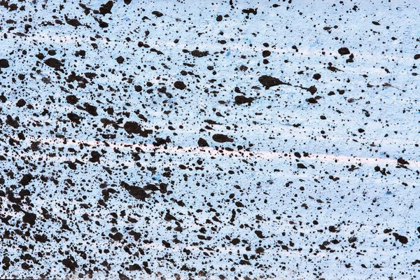 Black paint splatter on blue background — Stock Photo, Image