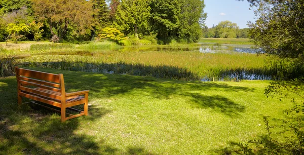 Пустая деревянная скамейка в парке — стоковое фото