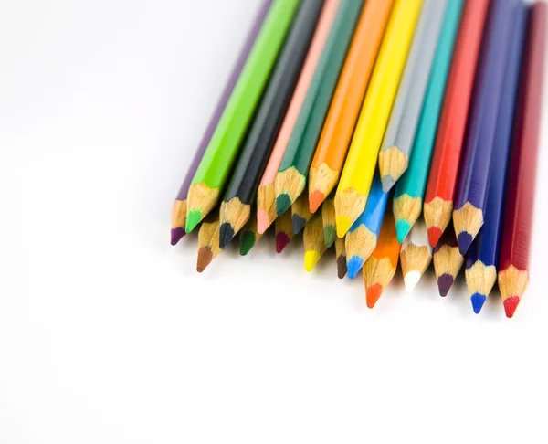 Lápis multicoloridos em um canto em um fundo branco — Fotografia de Stock