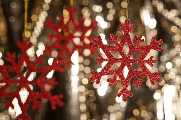 Flocon de neige rouge sur fond de paillettes dorées — Photo