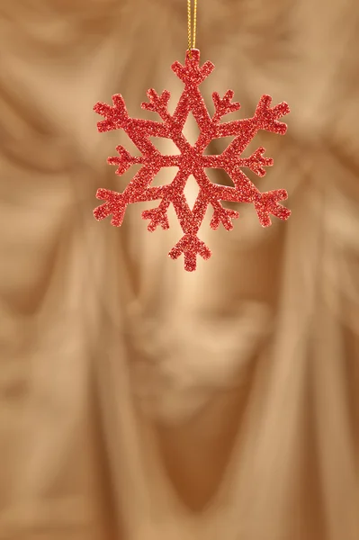 Red snow flake on a gold background — Stock Photo, Image
