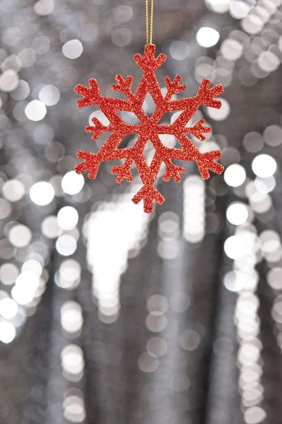 Fiocco di neve rosso su sfondo argento glitter — Foto Stock