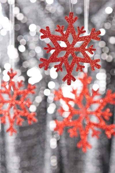 Fiocco di neve rosso su sfondo argento glitter — Foto Stock