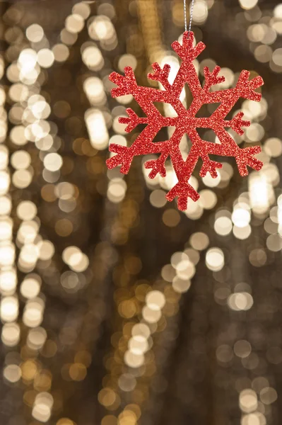 Röd snöflingan på guld glitter bakgrund — Stockfoto