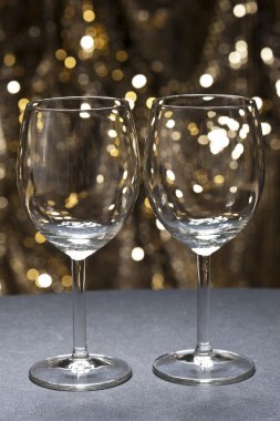 White wine glasses in front of glitter background clipart