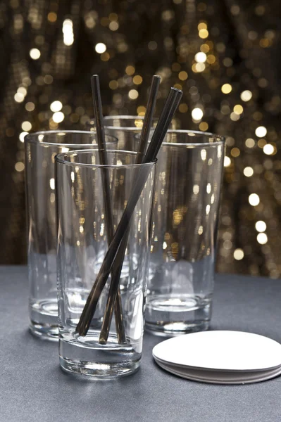 Copos de bebida longa com palhas e coaster na frente do glitter b — Fotografia de Stock
