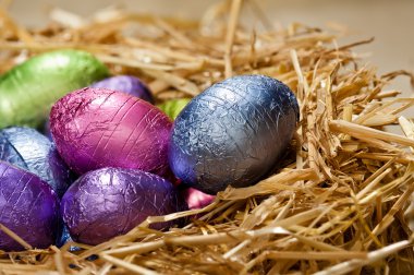 Chocolate Easter eggs in a natural straw nest clipart