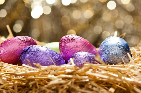 Chocolate Easter eggs in a natural straw nest — Stock Photo, Image
