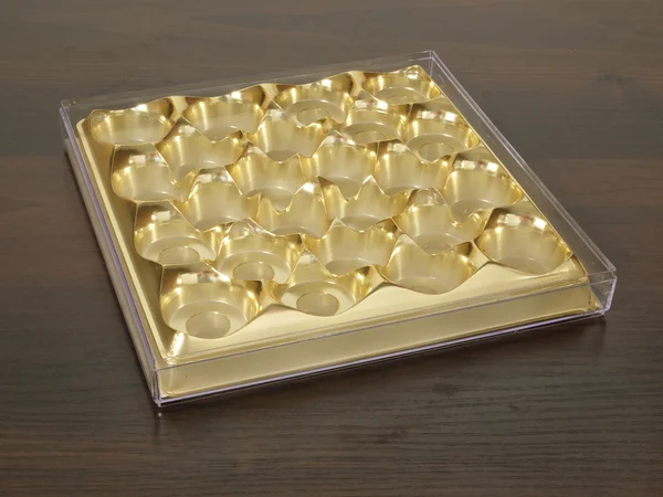 Пустой ящик из конфет золотого цвета на деревянном столе . Стоковое Фото