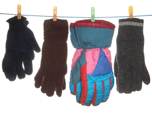 Eine Vielzahl von Handschuhen hängen an einem Seil, isoliert auf einem weißen Rücken — Stockfoto