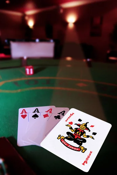 Four aces and a joker in spotlight — Stock Photo, Image