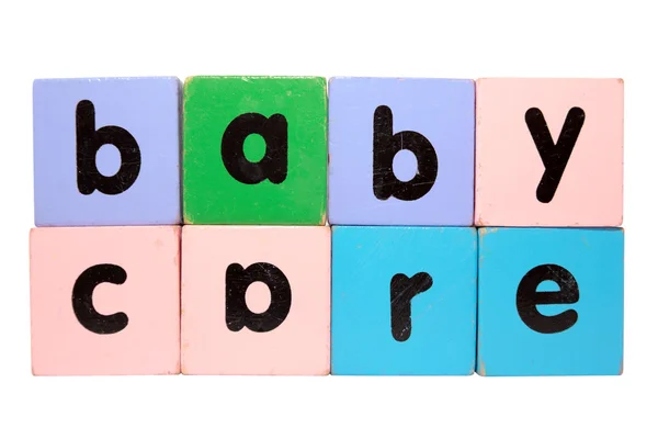 Cuidado do bebê no brinquedo jogar letras de bloco com caminho de recorte no branco — Fotografia de Stock