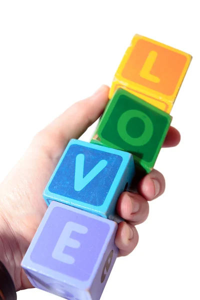 Amor en letras de bloques de juego de madera sostenidas en la mano — Foto de Stock