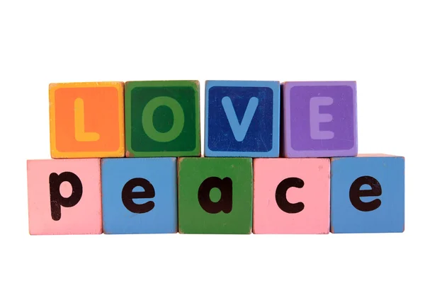 Liefde over vrede in hout spelen drukletters tegen Wit — Stockfoto