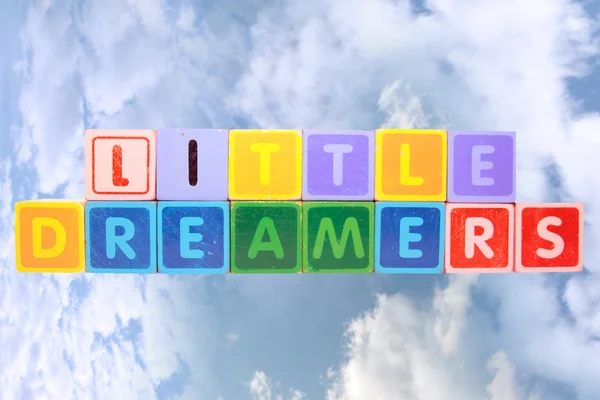 Pequenos sonhadores em blocos de brinquedo em nuvens — Fotografia de Stock