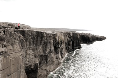 Lone person on cliffs edge clipart