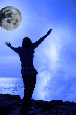 A woman with raised hands facing a wave and full moon on cliff e clipart