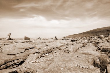 Sepia rocks in hilly rocky burren landscape clipart