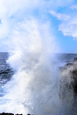 Giant wave crashing on cliffs clipart