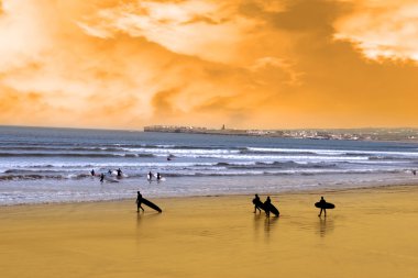 Sunset beach üzerinde yürüyen genç sörfçü