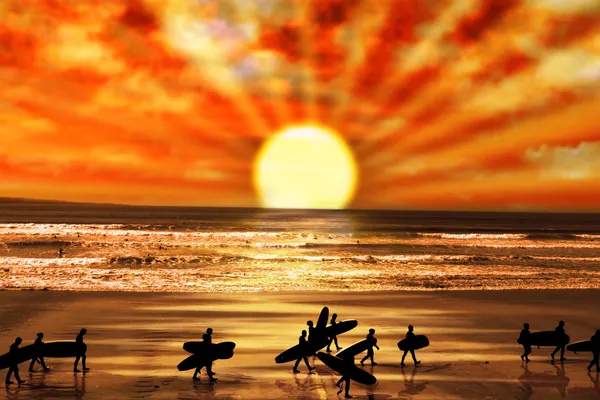 Surfers περπάτημα στην παραλία ηλιοβασίλεμα — Φωτογραφία Αρχείου