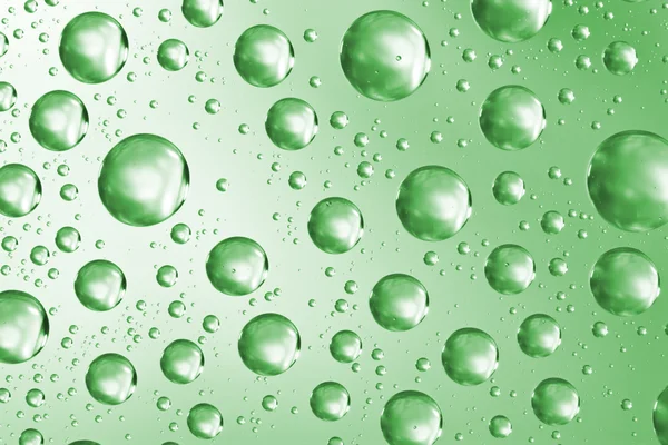 Yeşil cam yüzeyde su damlaları — Stok fotoğraf