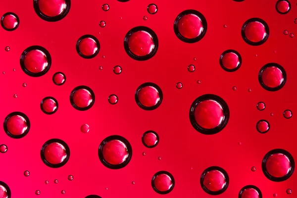 Gotas de agua sobre vidrio rojo — Foto de Stock