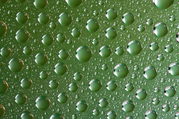Gouttes d'eau sur la surface en verre vert — Photo