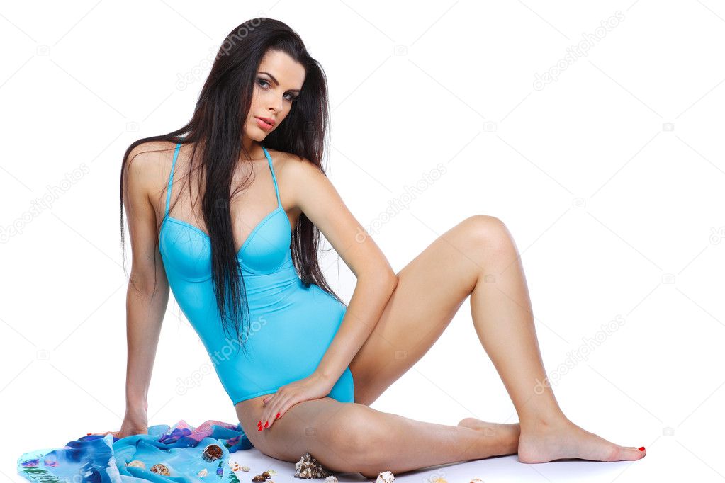 Attractive sexual brunette in a turquoise swimming suit on a white background
