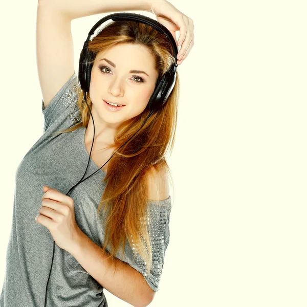 Menina bonita com fones de ouvido isolados em um fundo — Fotografia de Stock