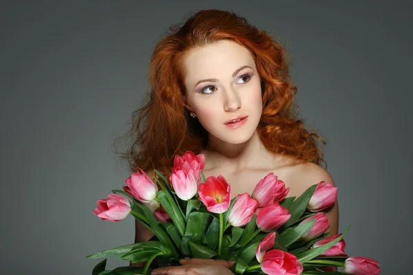 Όμορφη νεαρή κοπέλα redheaded με τουλίπες — Φωτογραφία Αρχείου