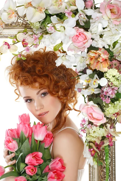 Beautiful redheaded girl with the bouquet of tulips, which stands in a gold frame, flowered, isolated on a white background — Stock Photo, Image