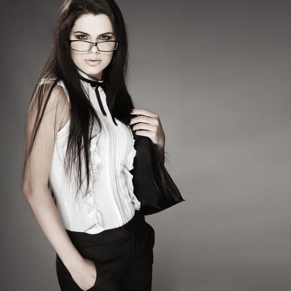 Schönes Mädchen in Businesskleidung auf grauem Hintergrund — Stockfoto
