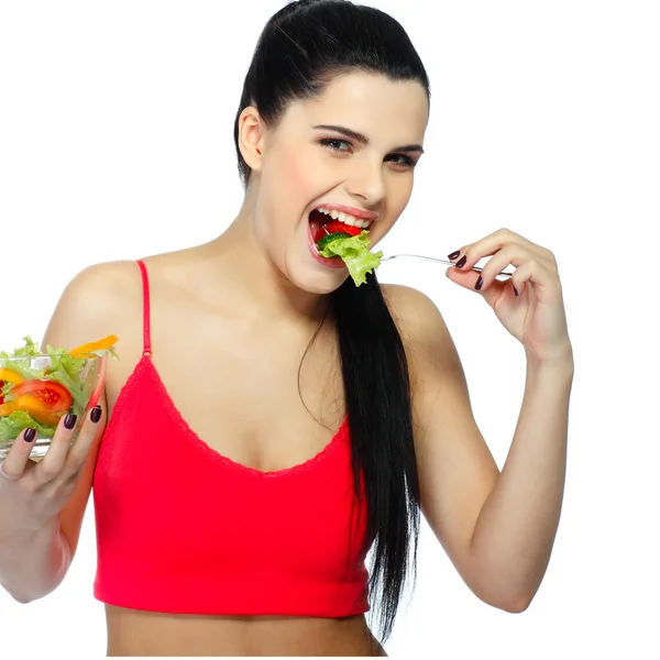 Retrato de una hermosa joven comiendo ensalada de verduras aislada sobre un fondo blanco —  Fotos de Stock