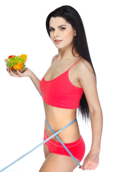 Retrato de una hermosa joven comiendo ensalada de verduras aislada sobre un fondo blanco — Foto de Stock