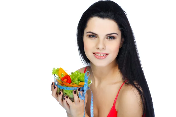 Retrato de una hermosa joven comiendo ensalada de verduras aislada sobre un fondo blanco — Foto de Stock