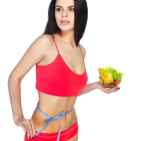 Portret van een mooie jonge vrouw eten plantaardige salade geïsoleerd op een witte achtergrond Stockfoto