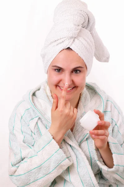 Beautiful girl rubs her nose with face cream — Stock Photo, Image